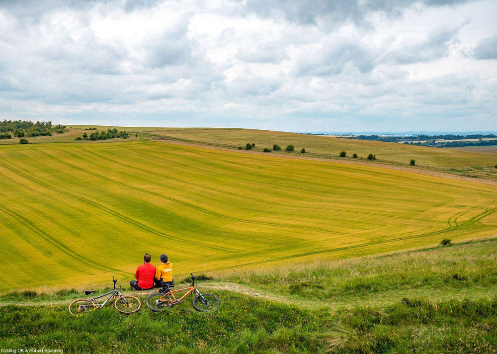 The Ridgeway - two mountain bikers sit on a hill looking at the view