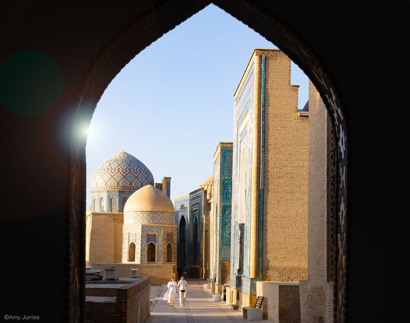 Looking through an arch at beautiful domed buildings in Uzbekistan